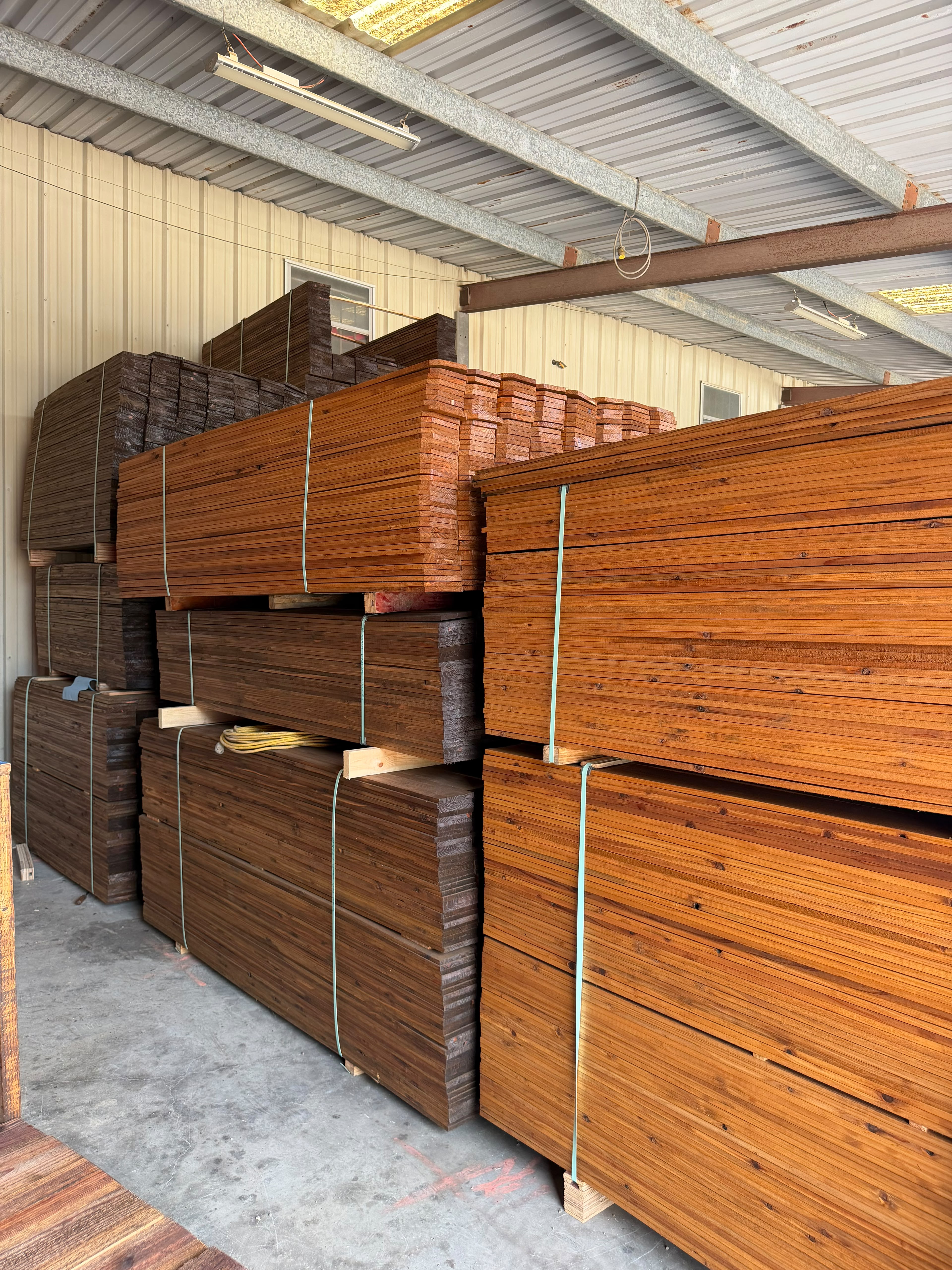 Stacked pre-stained cedar fence boards ready for pickup